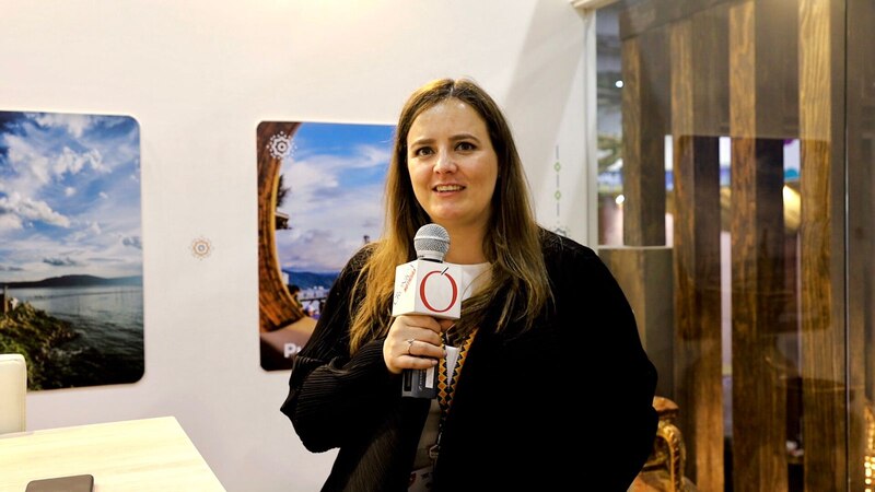 Una mujer da una entrevista en una feria de turismo.