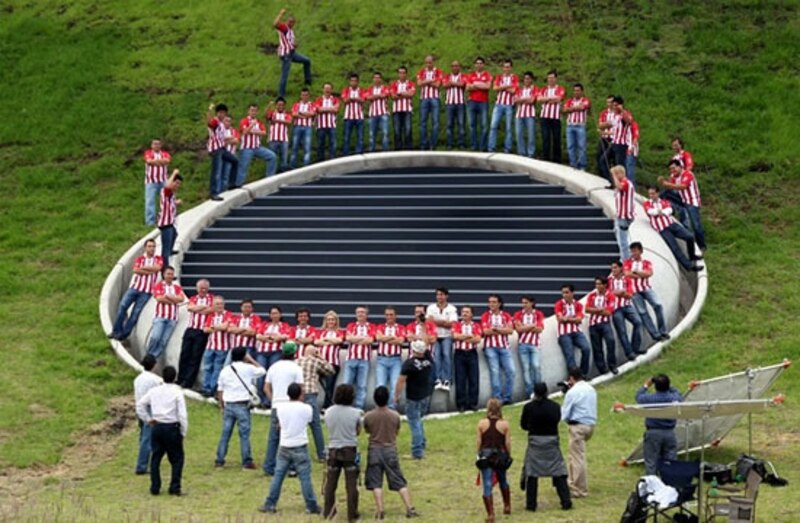 Jugadores de fútbol posan en un estadio vacío