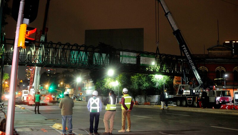 Trabajadores instalan un puente peatonal en la Ciudad de México