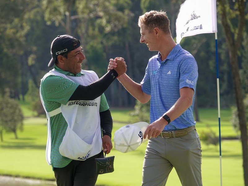 El golfista celebra con su caddy tras ganar el torneo