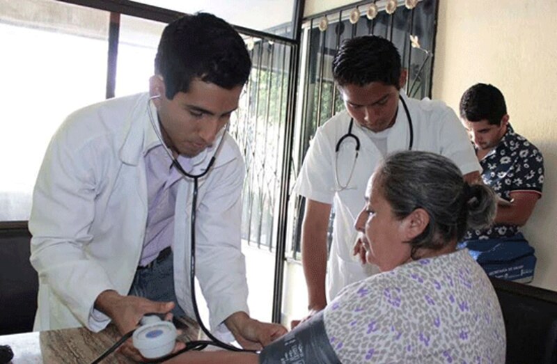 Médico tomando la presión arterial a una paciente.