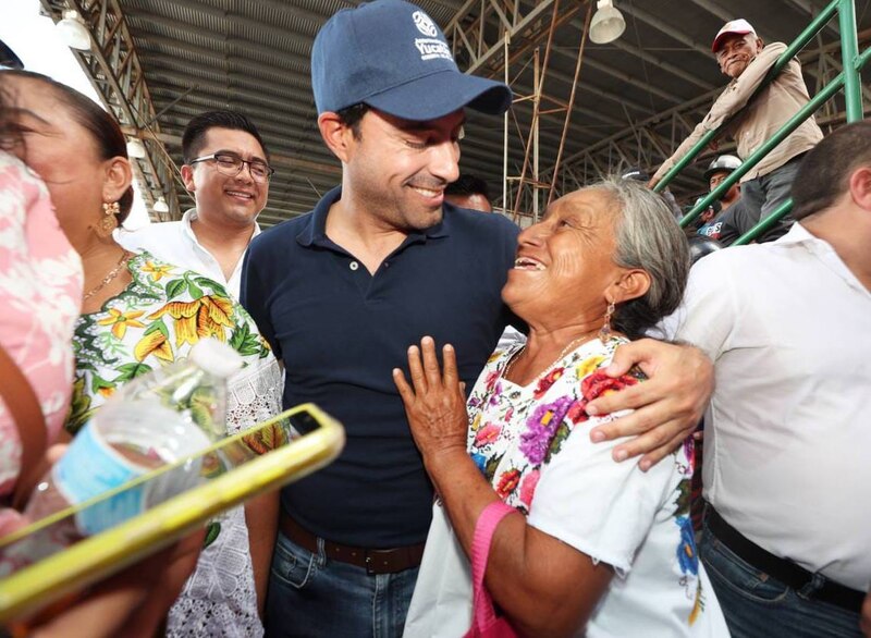 El candidato presidencial Andrés Manuel López Obrador abraza a una mujer indígena en un mercado.
