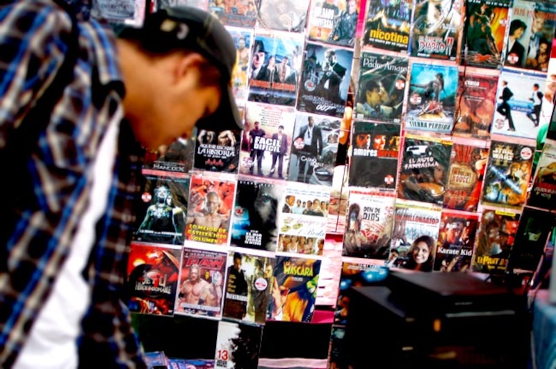 Un hombre mirando una pared de DVDs