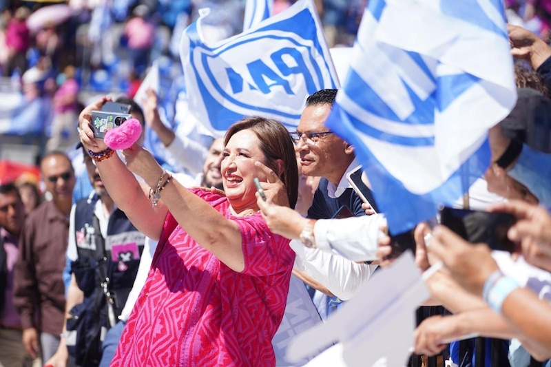 Claudia Sheinbaum, jefa de gobierno de la Ciudad de México, se toma una selfie con simpatizantes durante un evento público.