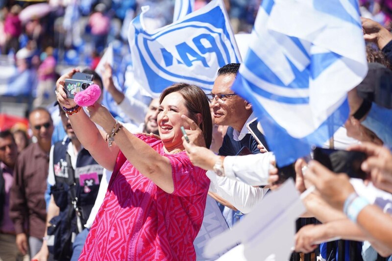 Claudia Sheinbaum, jefa de gobierno de la Ciudad de México, se toma una selfie con simpatizantes durante un evento público.