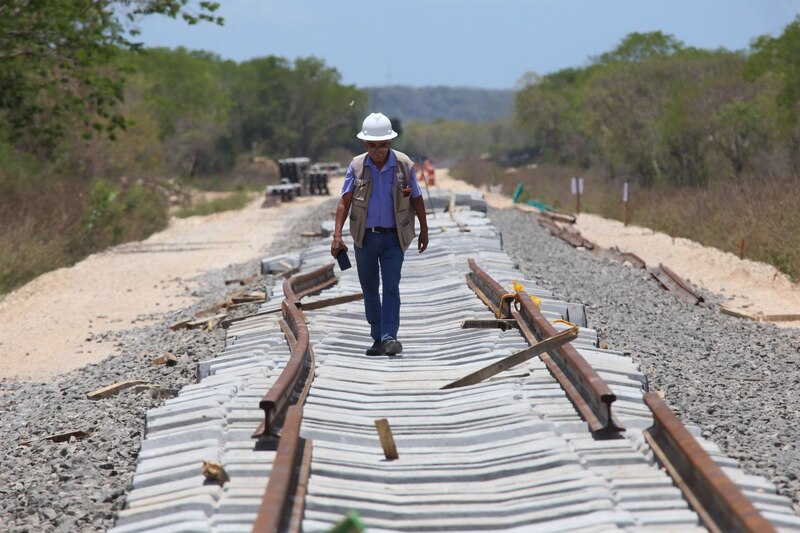 Un ingeniero camina sobre una vía férrea en construcción