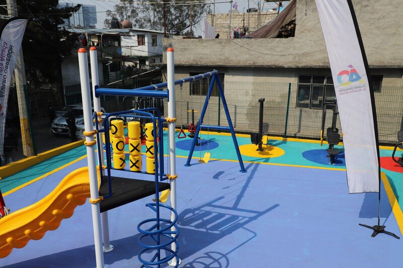 Parque infantil con columpios, tobogán y otros juegos