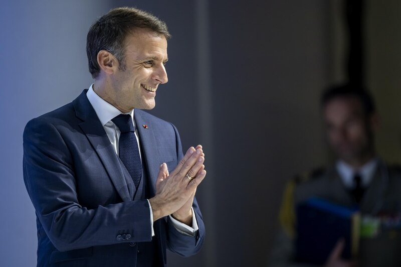 El presidente francés Emmanuel Macron sonríe durante un discurso.