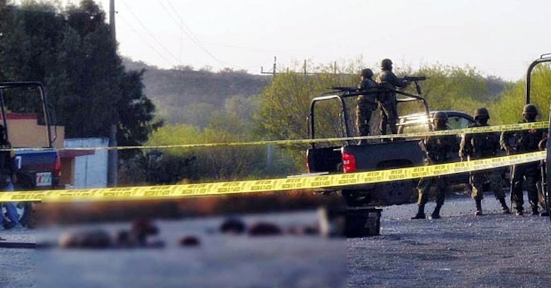 Soldados mexicanos resguardan el lugar donde fueron encontrados los cuerpos sin vida de varias personas en una carretera en el norte de México.