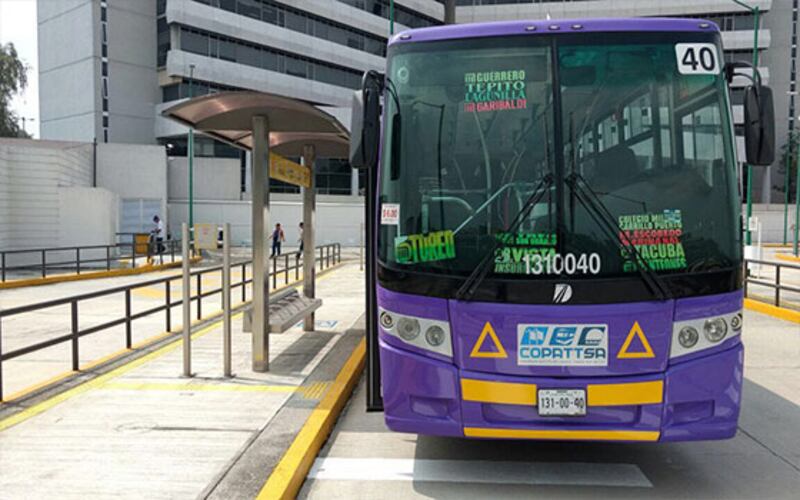 Autobús morado en una parada de autobús