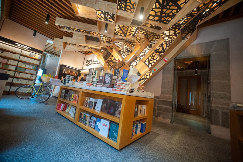 Librería con estanterías de madera y techo de vigas de madera.