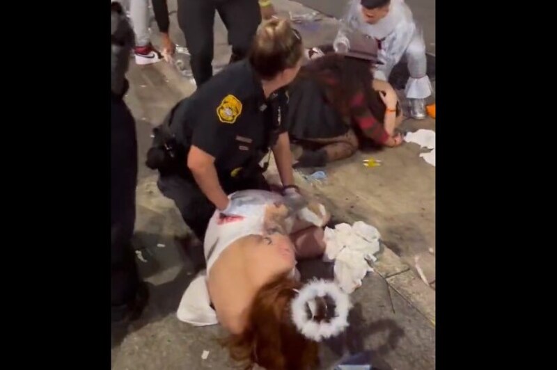 Mujer policía detiene a una mujer disfrazada de ángel en una fiesta de Halloween