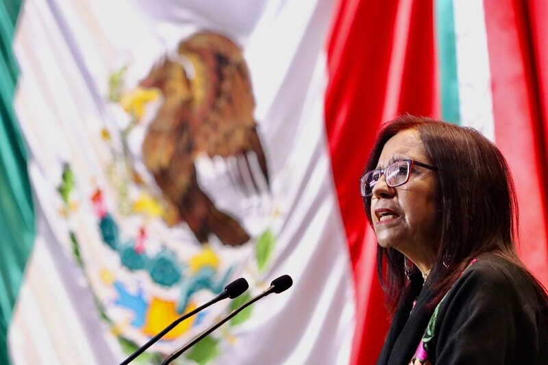La Secretaria de Gobernación, Olga Sánchez Cordero, da un discurso frente a la bandera de México.