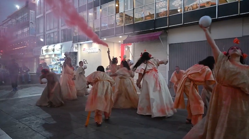 Mujeres indígenas realizan una danza tradicional en una calle de la ciudad.