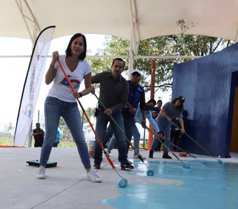 Voluntarios pintan un mural en una escuela