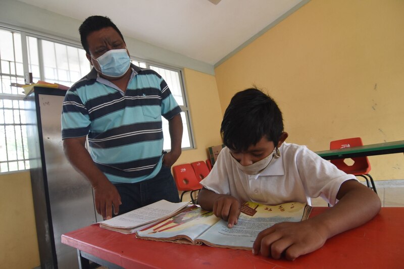 Profesor ayuda a un alumno con su lectura