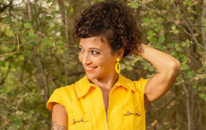 Mujer joven con vestido amarillo en el campo