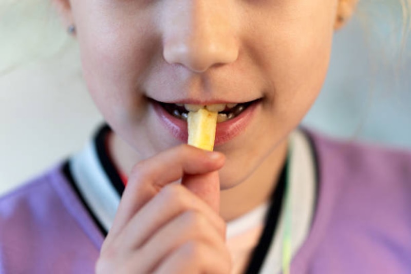 Niña comiendo patatas fritas