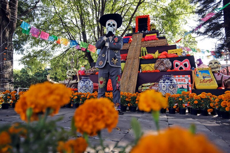 Un hombre disfrazado de catrín frente a una mega ofrenda de Día de Muertos, en la antigua Hacienda San Mateo del municipio de Atlixco