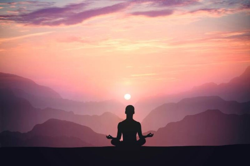 Mujer meditando en la montaña
