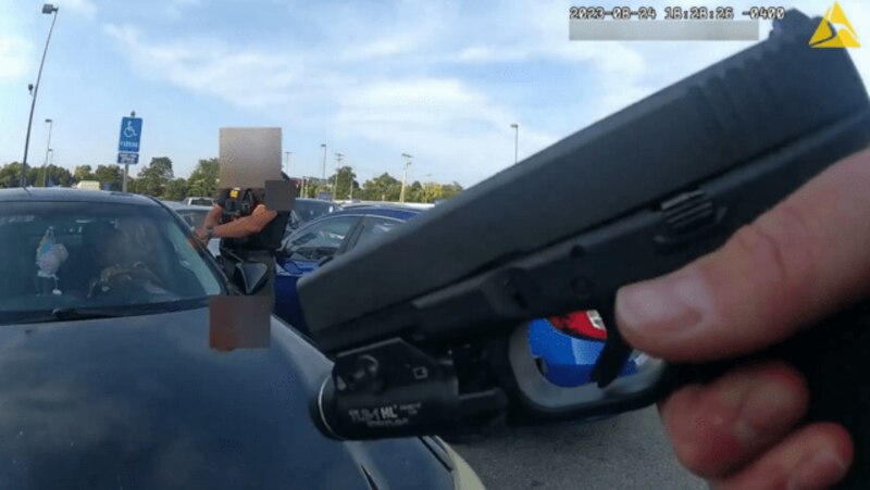 Policía apunta con una pistola a un conductor