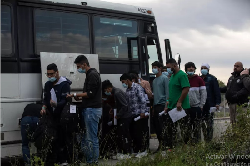 Migrantes esperan para abordar un autobús