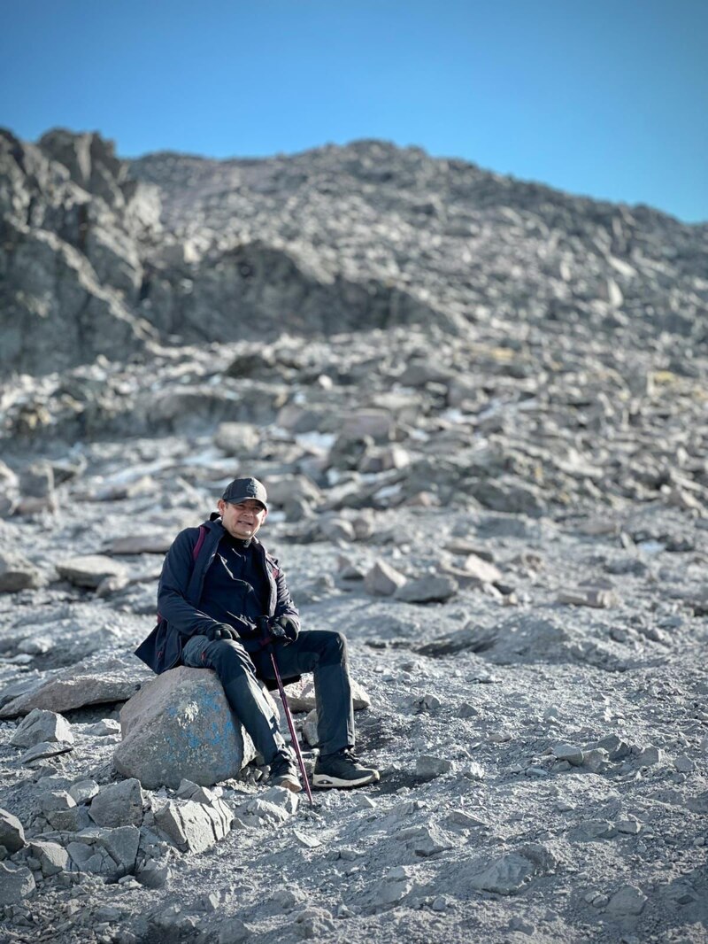 Excursionista descansando en la cima de una montaña