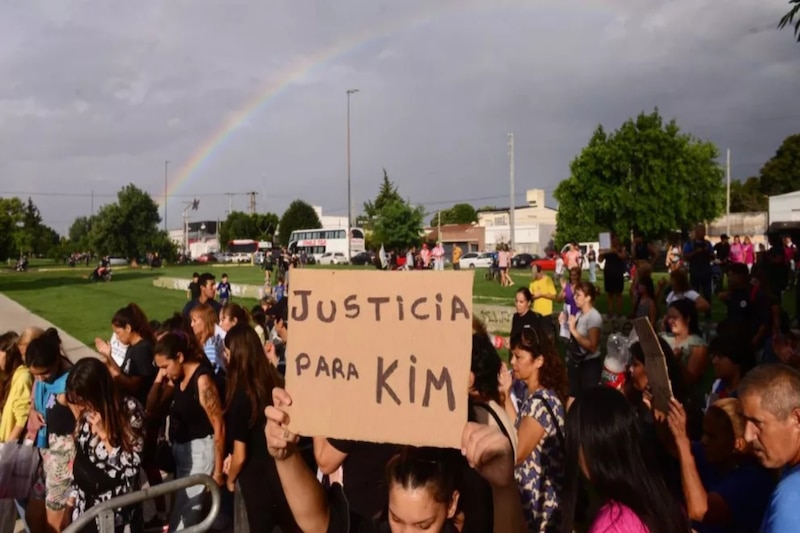 Grupo de personas reunidas con pancartas y velas en una vigilia pidiendo justicia por la niña asesinada en La Plata