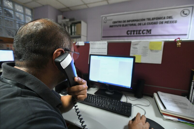 Un hombre atiende una llamada telefónica en una oficina.