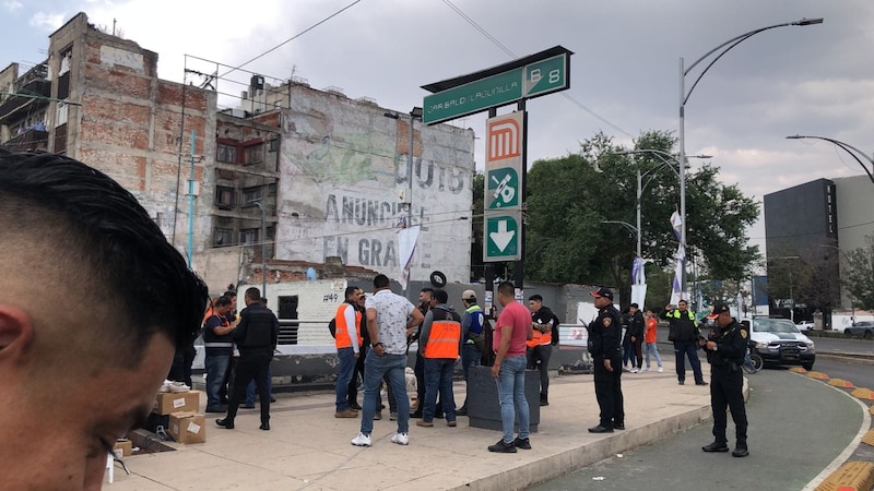 Multitud de personas en la calle mirando un anuncio en una pared