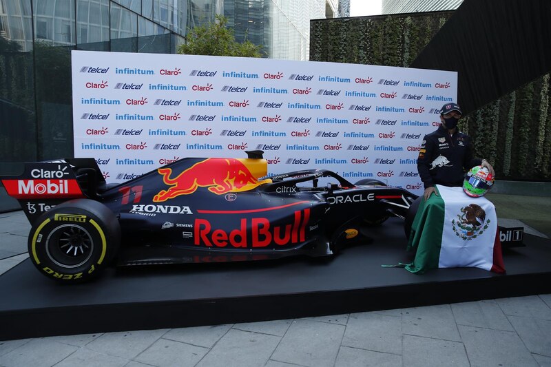 Sergio Pérez, el piloto mexicano de Red Bull, con su casco y junto al monoplaza RB18