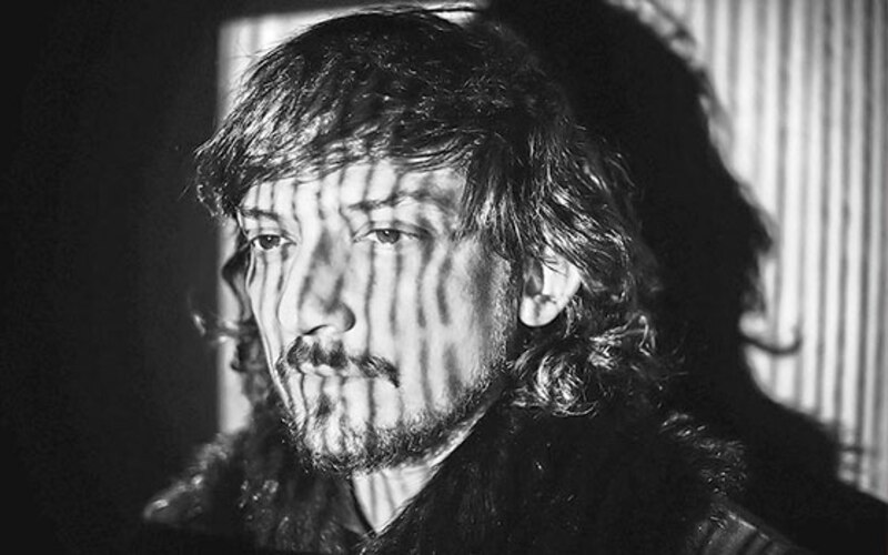 Retrato en blanco y negro de un hombre con barba y el pelo largo.