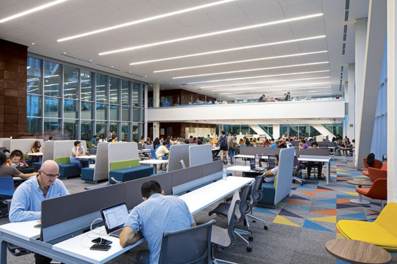 Biblioteca moderna con estudiantes trabajando