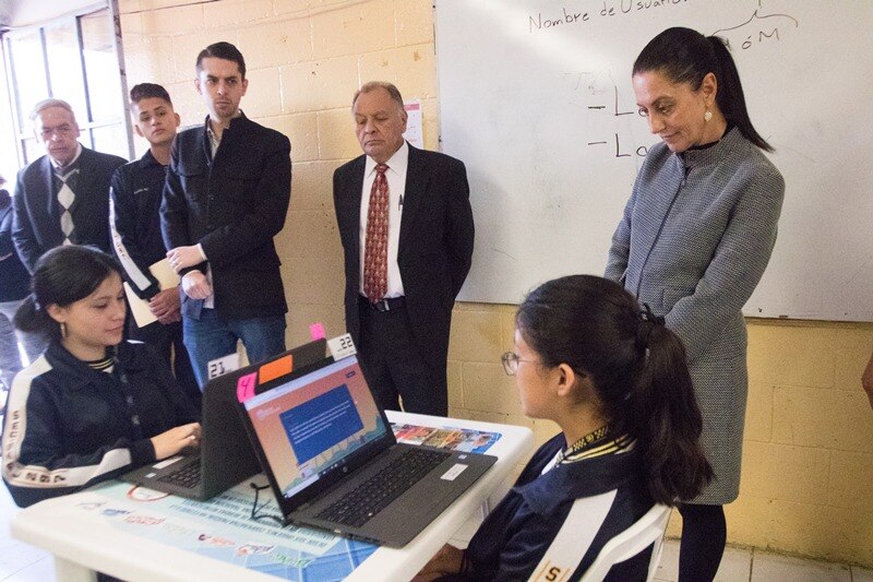 Niña usando una computadora portátil en una clase