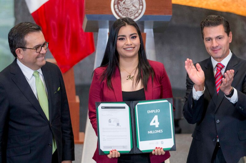 La Secretaria del Trabajo Luisa María Alcalde entrega el documento del programa Jóvenes Construyendo el Futuro a un joven aprendiz.