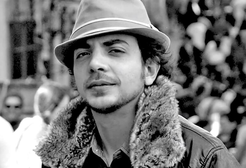 Retrato en blanco y negro de un hombre con sombrero y abrigo de piel