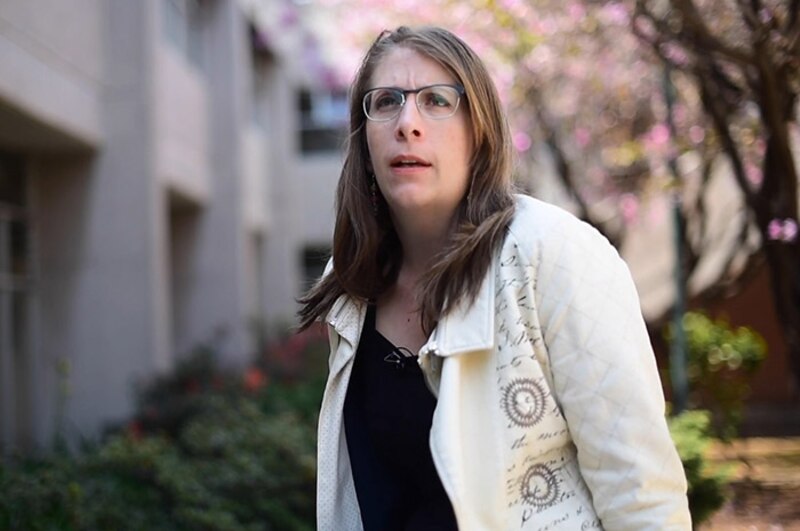 Mujer joven con gafas mirando hacia la izquierda