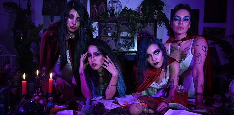 Cuatro mujeres jóvenes realizan un ritual de magia negra.