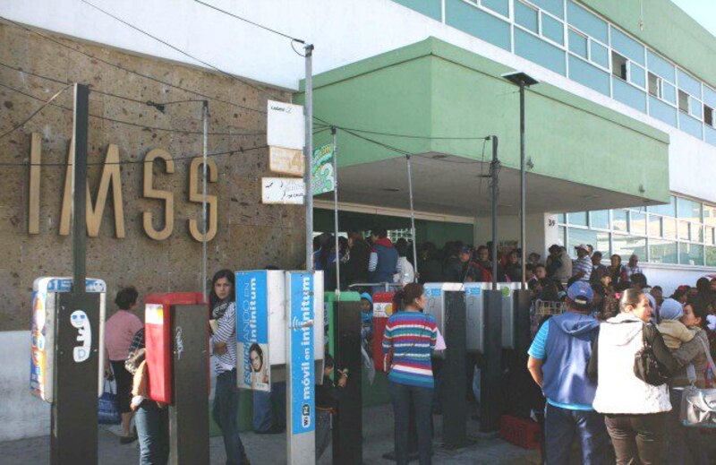 Larga fila de personas esperando para usar los teléfonos públicos en México