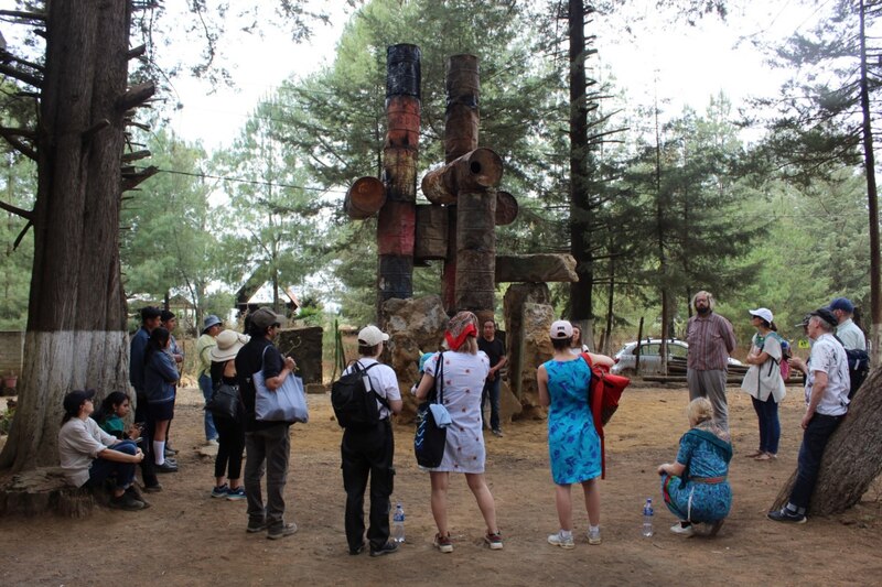 Un grupo de personas observan una escultura al aire libre.