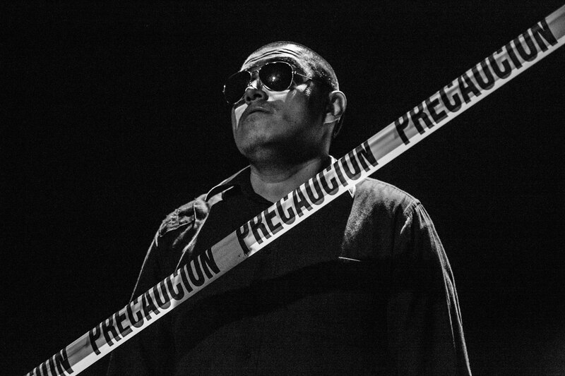 Un hombre con gafas de sol y una cinta de precaución en el pecho