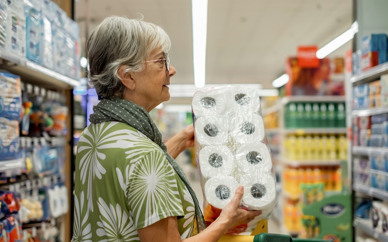 Mujer mayor comprando papel higiénico en el supermercado