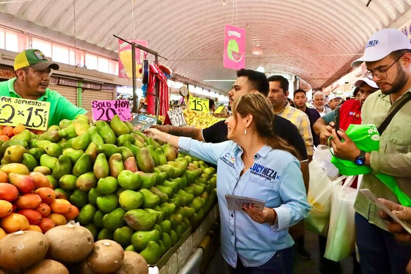 Title: La candidata a gobernadora Lucy Meza saluda a comerciantes en un mercado local