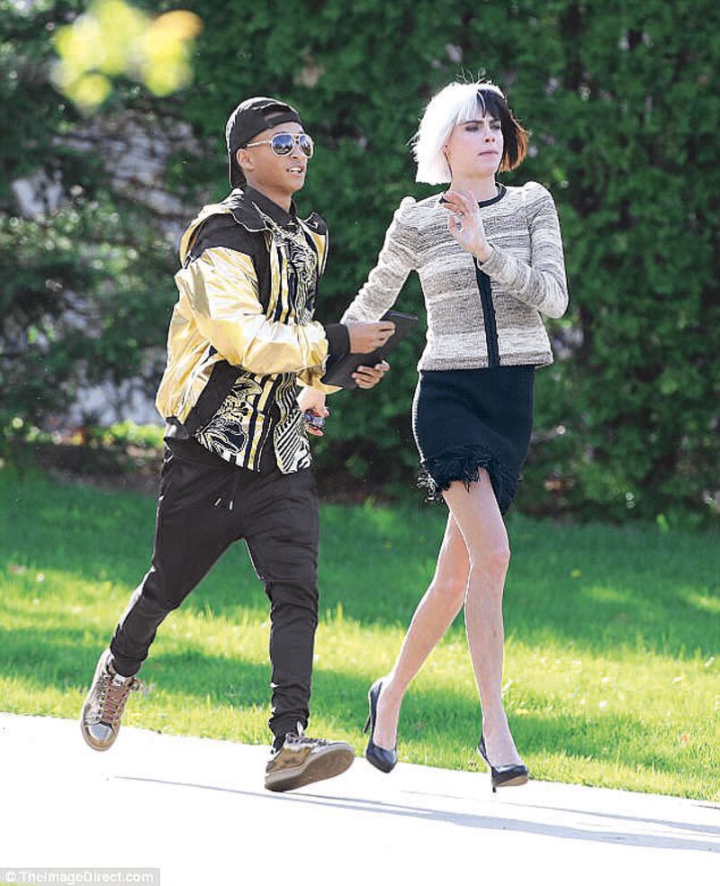 La modelo Cara Delevingne y el cantante Pharrell Williams caminan juntos por la calle.