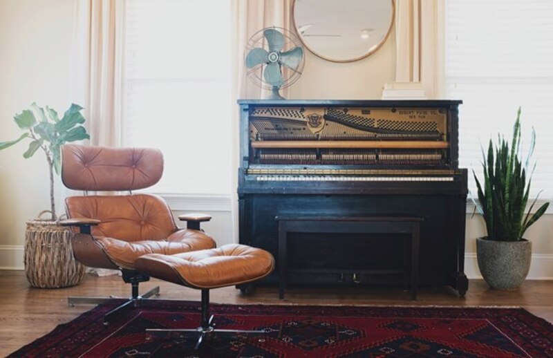 Elegante sala de estar con piano y sillón marrón