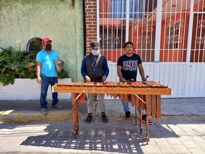 Tres hombres tocando la marimba en la calle.