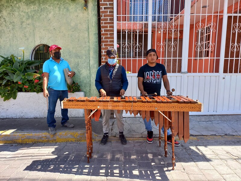 Tres hombres tocando la marimba en la calle.