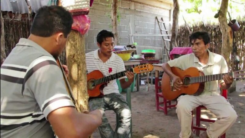 Tres hombres tocando música en una casa