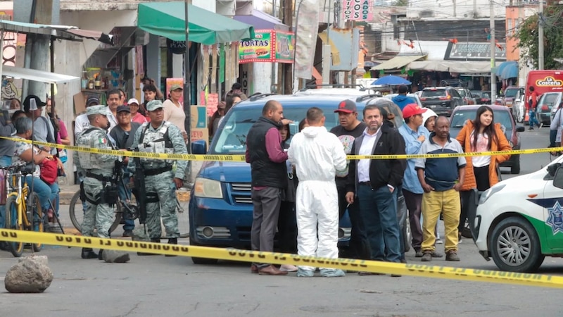 Multitud de personas rodea a un grupo de policías que investigan una escena de crimen