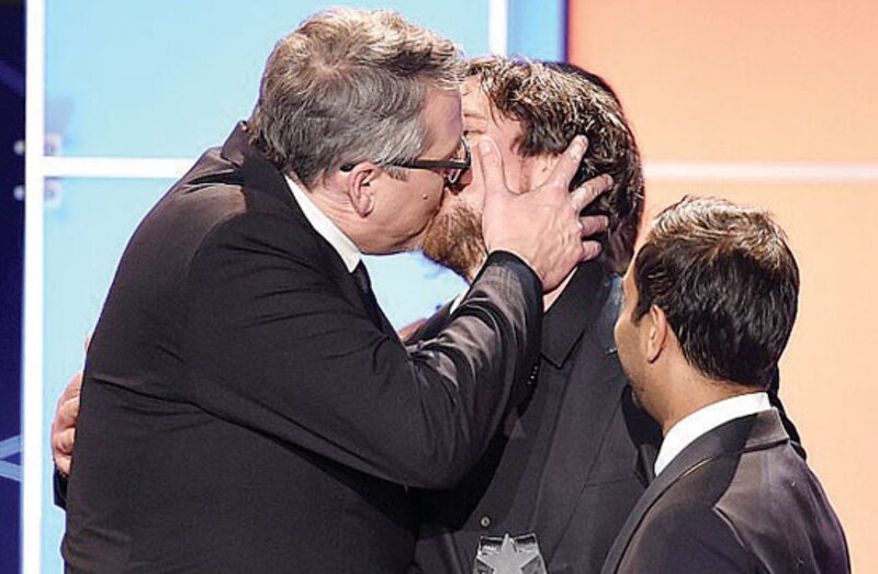 Un beso entre tres hombres en una premiación